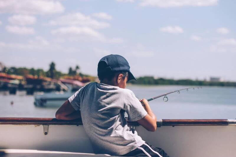 boy on boat fishing